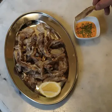 Fuente de fritura con limón y una salsa para mojar